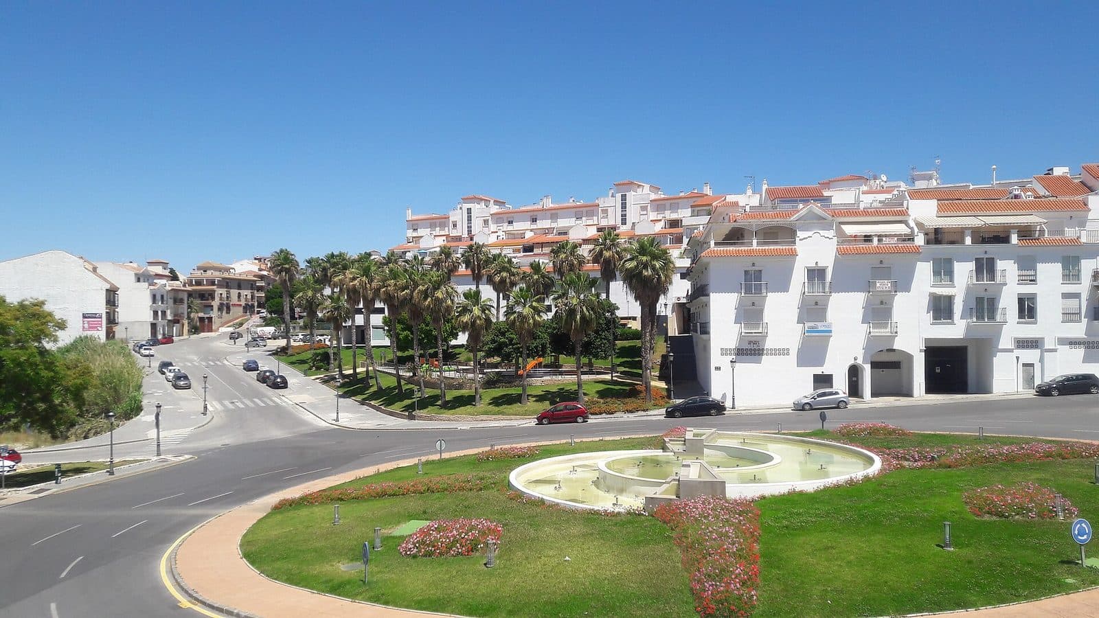 The roundabout on the edge of Alhaurín el Grande, white apartment blocks and palms