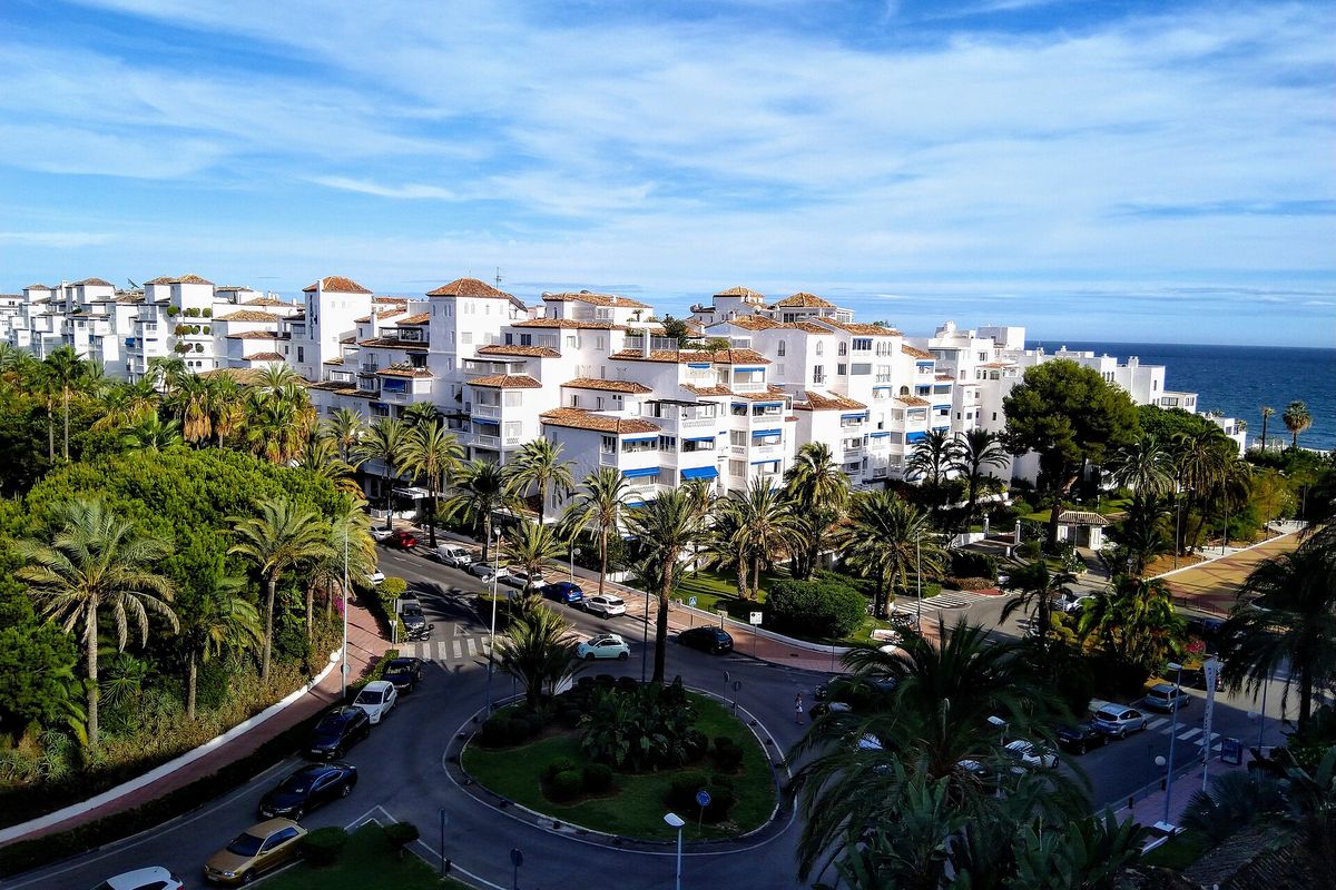 Apartment blocks between the port and the beach, with the sea behind