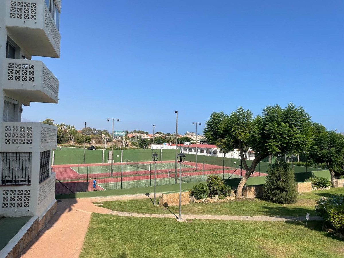 The view from the living room over the tennis courts to the sea